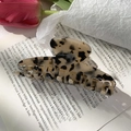 Detalle de una pinza grande para el cabello con estampado de leopardo sobre un libro con tulipas - Leopardo Claro