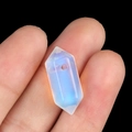 Handheld view of a polished milky white synthetic opal hexagonal prism crystal pendant - Synthetic Opal