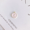 Detailed view of round pink enamel pendant with gold letter Z for DIY jewelry making - Letter Z