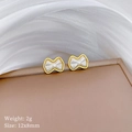 Macro shot of minimalist bow stud earrings with gold trim and white mother-of-pearl - Gold (T323)