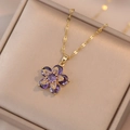 Elegant gold flower necklace with purple cubic zirconia petals in a velvet jewelry box - Purple Rotating Flower (X1590)
