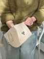 Pochette à maquillage matelassée beige tenue à la main avec étiquette de chat noir - Beige