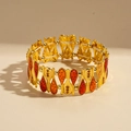 Dettaglio di un bracciale dorato boho con ciondoli a goccia rossi e arancioni - Rosso (Braccialetto)