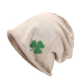 Detail einer beige gerippten Strickmütze mit einem lebhaften grünen Kleeblatt-Muster - Khaki