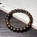 Ethnic green sandalwood barrel bead bracelet with natural wood grain on vintage book - Medicine Sandalwood 8x9mm