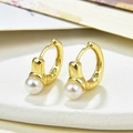 Elegante gouden huggie oorbellen met witte parels op een minimalistische stenen standaard - Minimalistische Enkele Parel Huggie