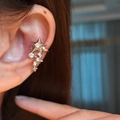 Dettaglio del polsino per orecchio a stella in argento con zirconi indossato sulla cartilagine - Ear Cuff - Pezzo singolo / Argento