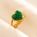 Close-up of green malachite heart ring with golden braided texture on beige fabric - Gold-Green Stone