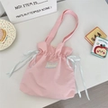 Detail of pink canvas drawstring tote bag with premium silk ribbons and woven studio label - Light Pink