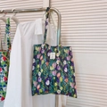 Dettaglio di una borsa tote in tela floreale con stampe di tulipani ed etichetta in tessuto - Tulipano Verde Viola