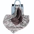Zebra pattern silk square scarf draped on a light blue leather handbag shown in studio - Brown and White Zebra Print