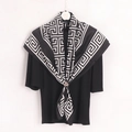 Detail of Greek key pattern silk scarf styled with a scarf clip on black top - Black