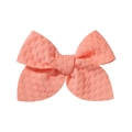 Close-up of coral pink bow hair clip with textured waffle fabric and secure alligator clip - Coral Pink