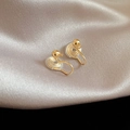 Detail of gold clip-on earrings with soft silicone pads on a champagne silk fabric - U-shaped Ear Clip / Gold