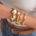 Detailed view of three polished gold-tone geometric textured bracelets on a wrist - Gold (3-Piece Set)