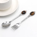 Vintage metal spoon and fork set with tiger eye stone handles on a white background - Tiger's Eye