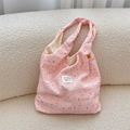 Close-up of pink bubble textured fabric with cute rabbit print and woven brand label - Skateboard Rabbit