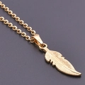 Minimalist gold feather pendant necklace in stainless steel on black background - Gold Necklace