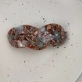 Detailopname van Franse gevlochten haarklem met blauwe en bruine marmeren textuur - Groen Bruin Gemengd
