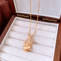Primer plano del collar con colgante de pluma chapado en oro de 18k en estuche de madera y cojín - Collar de Plumas-Dorado (Chapado en Oro de 18K)