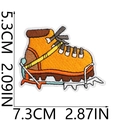 Detail of yellow hiking boot embroidered patch with 7.3cm and 5.3cm size indicators - Outdoor Boot Style