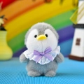 Macro view of a cute grey penguin plush keychain with a purple bow and white lace collar - 12cm / Gray