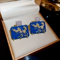 Details von Vintage-Emaille-Ohrringen mit goldenen Pflaumenblüten und lila Edelstein - Silbernadel-Blau