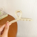Large matte cream-colored shark hair claw clip held by hand for thick hair styling - 11cm / Yellow