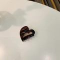 Detail shot of heart-shaped amber acetate hair claw clip with a hollowed design - Approx. 4cm / Glossy Red Brown