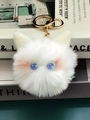 Detail of plush cat keychain with blue star-patterned eyes and golden hardware - Lavender
