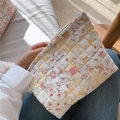 Detail van een gewatteerd stoffen tasje met bloemenprint en stoffen label - Geel Bloemen Gewatteerd