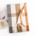 Plaid scarf in beige orange and grey with tassels displayed on a cozy table - Light Orange
