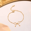Minimalist gold plated titanium steel bow bracelet set with bead chain on silk background - Bow Bracelet / Gold