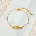 Detailaufnahme der goldenen Hufeisenschließe und weißen Perlen am Gliederarmband - Perlendekor / Goldenes Perlenarmband