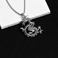 Vue détaillée du collier pendentif dragon en argent vieilli sur fond de pierre brute - Dragon en Argent Antique Robuste
