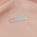 Close-up of heart cutout stainless steel pendant on pink silk fabric background - Steel Color (MP387-6)