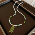 Elegante Goldkette mit weißen Perlen und grünen Edelsteinen auf einem Tablett - Stil 56# Halskette-Weiße Perle Grüne Jade Goldener Rahmen