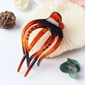 Glossy amber tortoiseshell hair claw clip with multi-tooth design on a white background - Coffee Stripes
