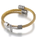 Modern twisted cable bangle in gold and silver finish with a centered cross motif - Gold and Silver Tone