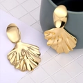 Golden fan-shaped earrings with textured shell finish in a minimalist still life style - Fan Shell Texture Drop Earrings / Gold