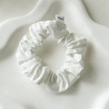 White cotton fabric scrunchie with soft pleats on a white ceramic tray for hair styling - White