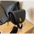 Close-up of black leather saddle bag featuring a textured gold buckle and adjustable strap - Black
