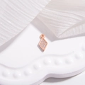 Macro-opname van roségouden ruitvormige hanger met micropavé witte zirkonia-kristallen - Ruit / Roségoud