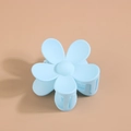 Gros plan d'une pince à cheveux fleur bleu clair avec finition mate et motif à cinq pétales - Bleu clair