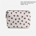 White crinkled cosmetic bag with black bow patterns and pearl zipper pendant detail - Black White Bow Clutch
