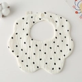 Macro shot of petal-shaped muslin cotton baby bib with black polka dots on beige - Gauze Flower Scarf - Large Polka Dots