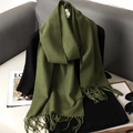 Detail of soft green autumn scarf with fringe styling on a black outfit background - Emerald Green