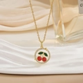 Elegant gold cherry pendant necklace with red enamel and white zircon inlay on silk background - Red Enamel Ring Cherry Style (XL0582)