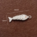 Silberner beweglicher Koi-Fisch-Anhänger mit orangem Edelsteinauge auf braunem Filz - Silber / Groß / Einzelstück