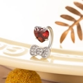 Silver horseshoe ring with red heart gem and rhinestone bow in high-detail macro shot - Single Piece / Red